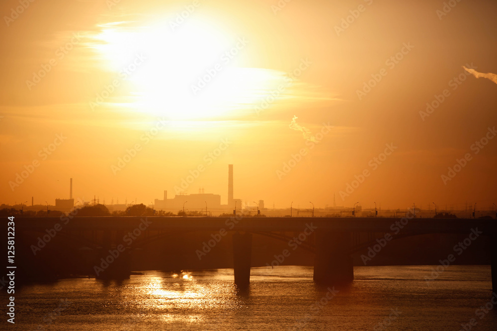 Beautiful sunset over silhouette city skyline and river