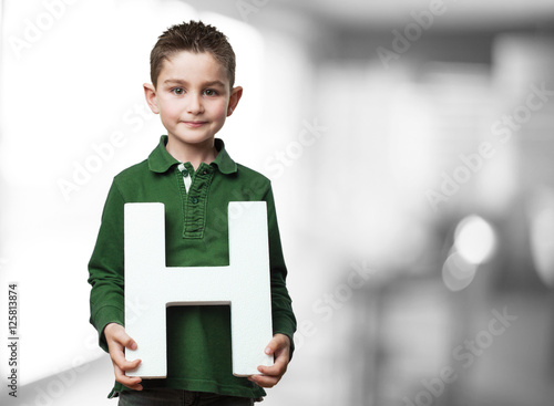 little kid holding the h letter