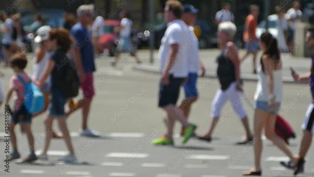 Side view blurred pedestrians crossing a street in the city of Barcelona in summer.Slow 
Motion