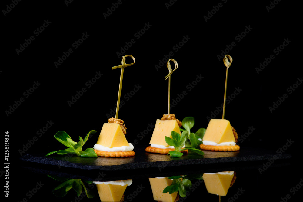 cheese crackers on black background with reflection cheese crackers on black background with reflection