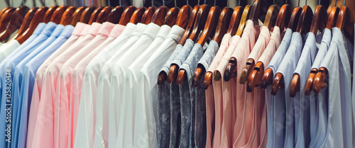 close up clothes hang on clothes rack in clothing store with swe