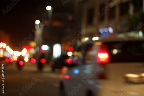 Defocused view of a car moving towards the town with blurred background and defocused city lights.