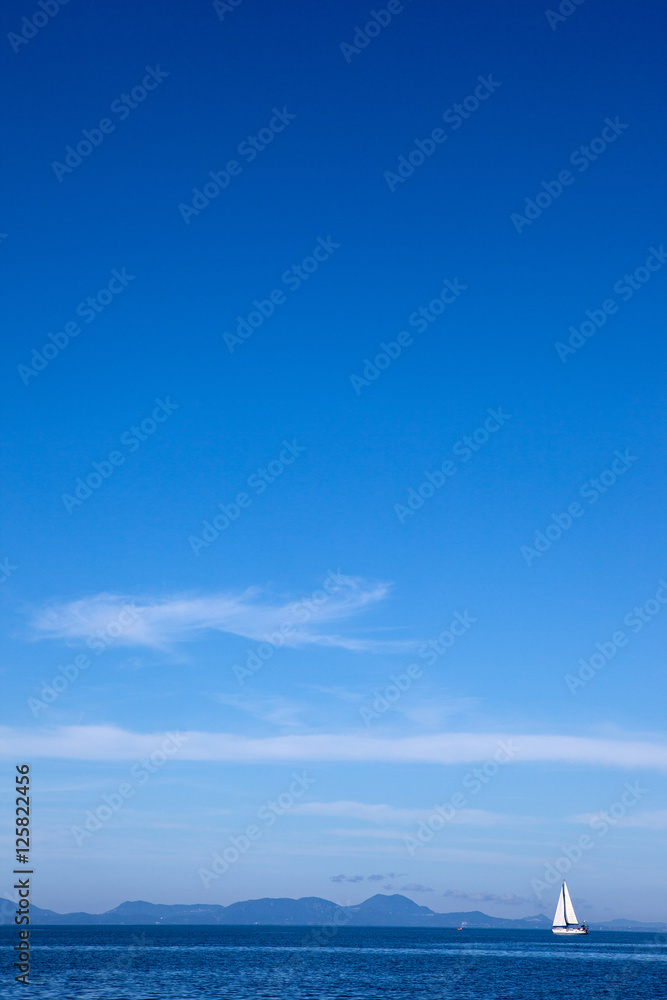 Naklejka premium white yacht traveling at sea against a blue sky