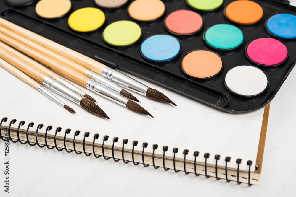 Watercolor paint set and new brushes with clean paper Watercolor paint set and new brushes with clean paper