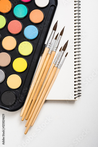 Watercolor paint set and new brushes with clean paper