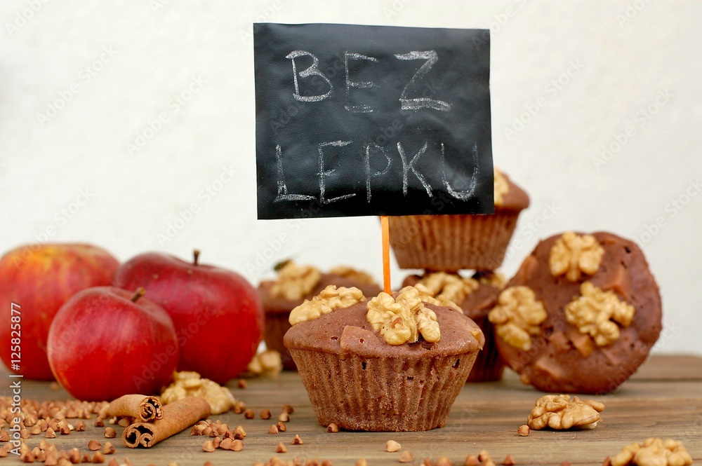 Gluten free muffins from buckwheat flour, apple, cinnamonand walnuts on brown wooden background with index card with text no gluten in czech language Gluten free muffins from buckwheat flour, apple, cinnamonand walnuts on brown wooden background with index card with text no gluten in czech language