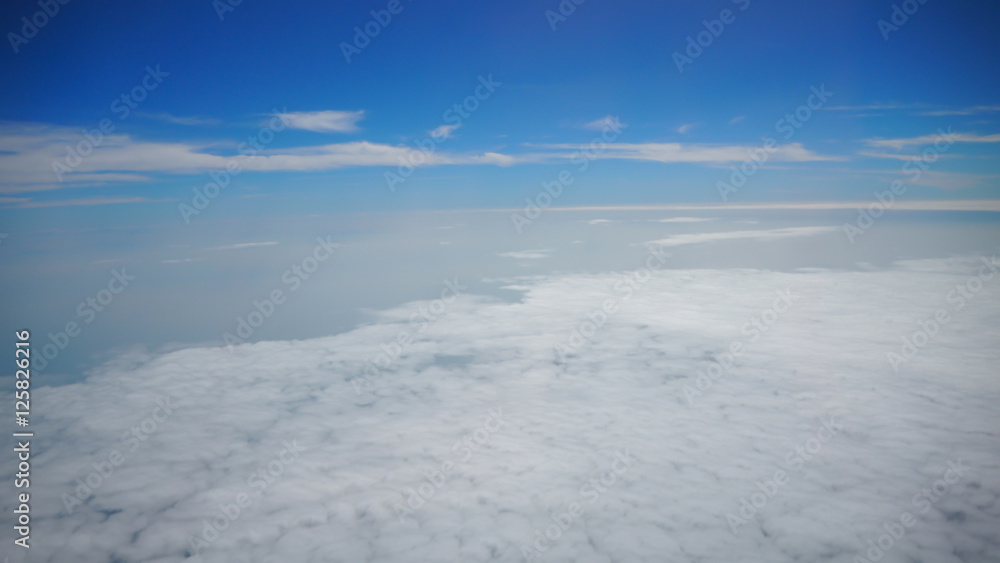 White cloud and blue sky in background view from airplane window while travelling.