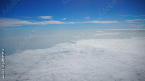 White cloud and blue sky in background view from airplane window while travelling.