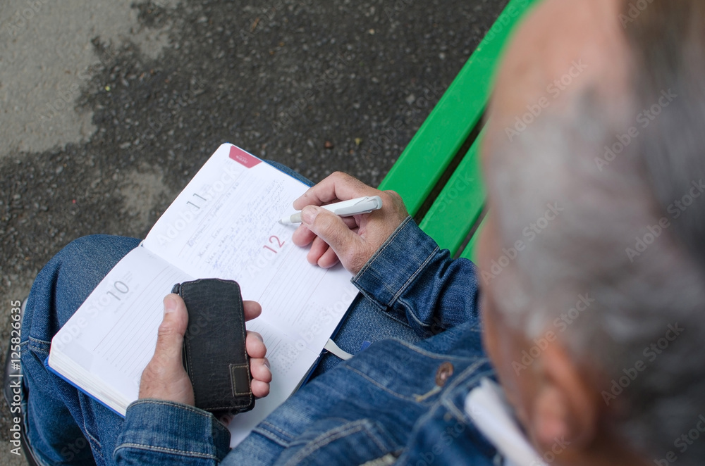 man is making notes in the daily planner man is making notes in the daily planner