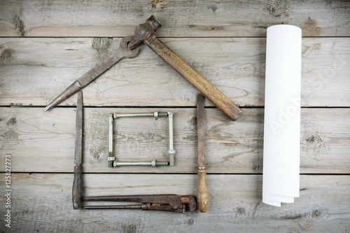 The concept of a house under construction. Old wooden desktop. Old rusty carpentry tools. Horizontal mockup