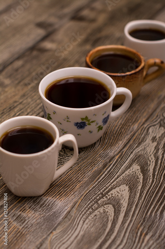 Four cups of coffee on wooden background