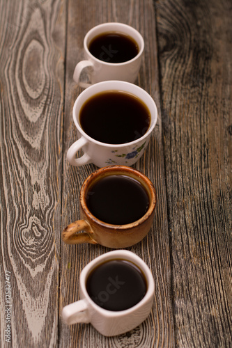 Four cups of coffee on wooden background