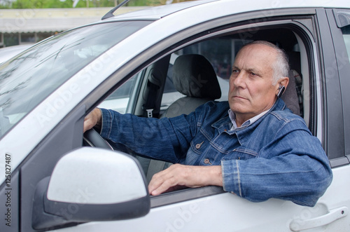 Aged man sitting in the car