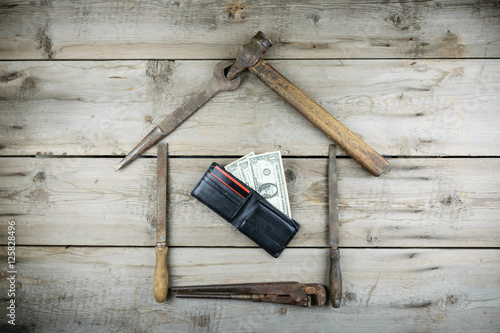 The concept of a house under construction. Old wooden desktop. Old rusty carpentry tools. Horizontal mockup