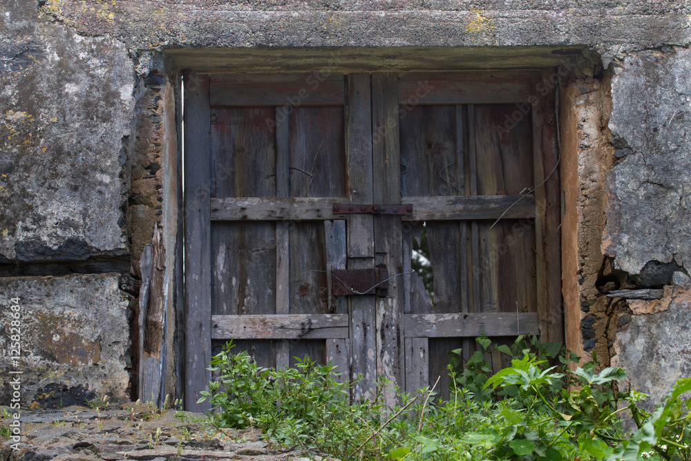Old wooden door or gate and metal wires of the rusted lock. Outside the house, village, everything comes into disrepair Old wooden door or gate and metal wires of the rusted lock. Outside the house, village, everything comes into disrepair