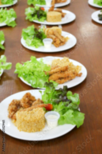 blurred of food, fried rice and breaded fried chicken in white p