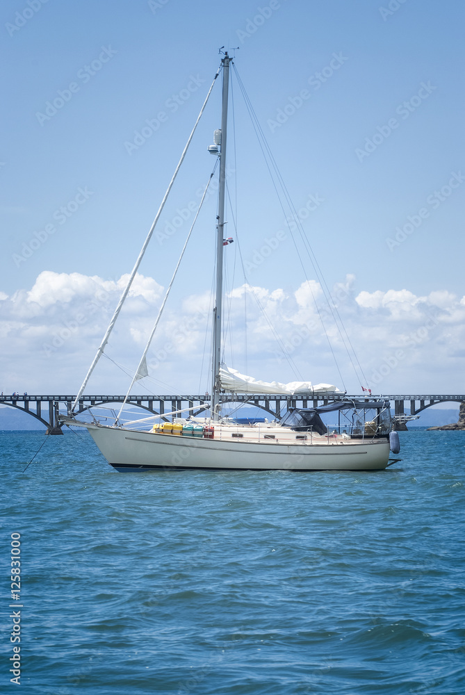 View of a sail boat ancored at Samana Bay and Los Puentes bridge