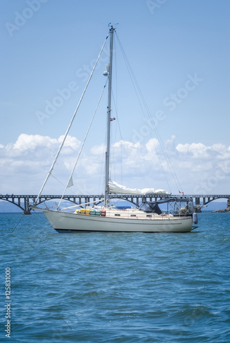 View of a sail boat ancored at Samana Bay and Los Puentes bridge