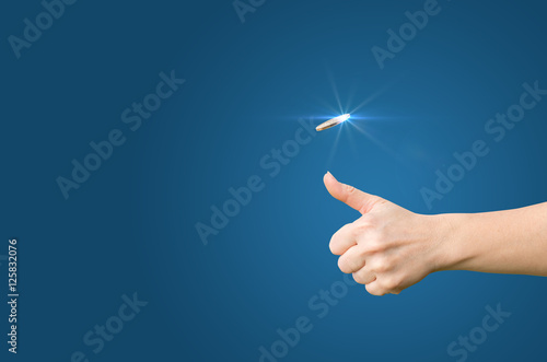 Hand throws a coin on a blue background for decision-making photo