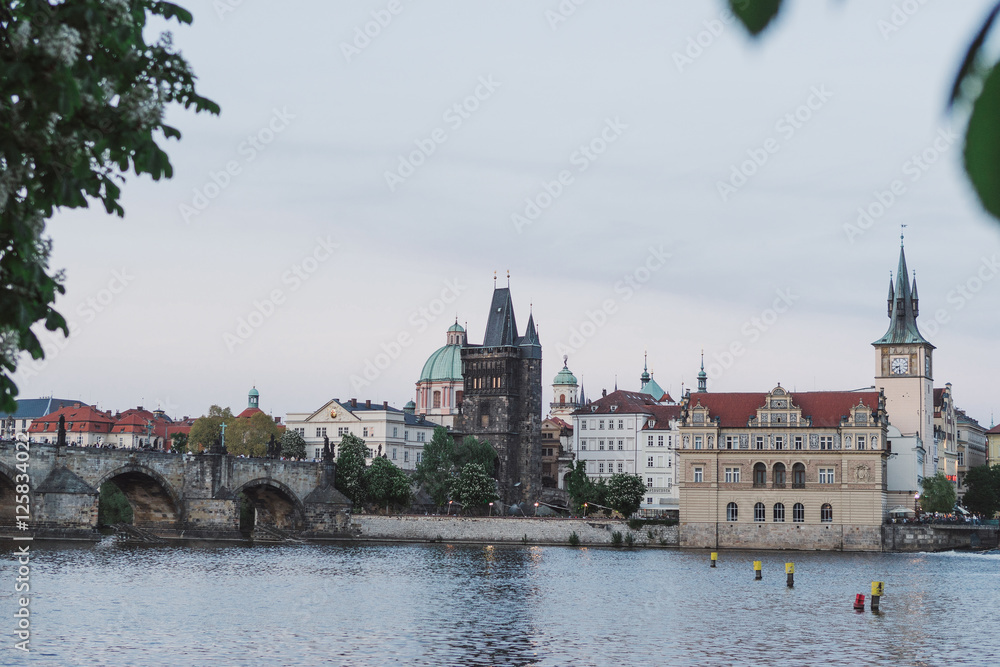 Prague cityscape in spring. View of old city center from the opposite bank of Vltava river after sunset