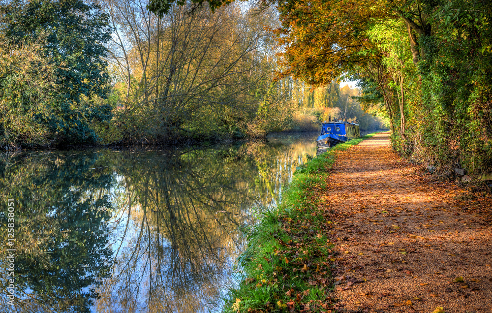 British autumn landscape. Blue narrow boat on the canal