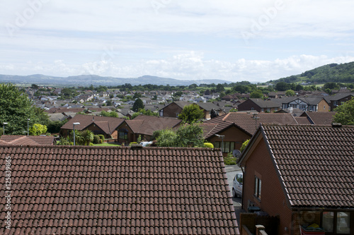 Row house roofs, condo rooftop panorama and bright summer cloudscape with Mountains in background UK