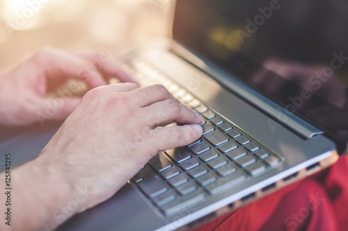 Closeup of Man's hands working on Laptop