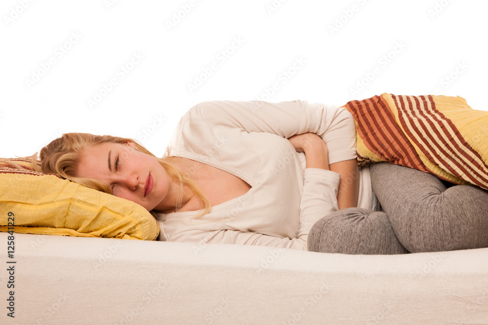 Woman lying in bed holding belly because of the pain in stomac. Woman lying in bed holding belly because of the pain in stomac.