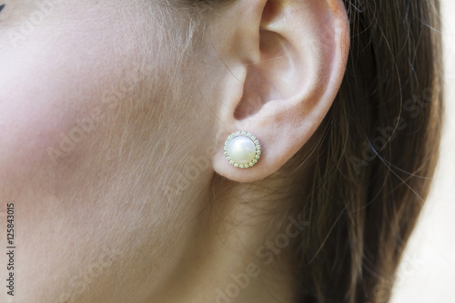 Canvastavla Woman's ear wearing an earring