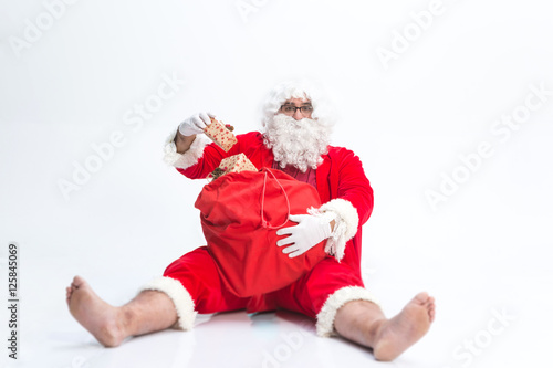  Portrait of happy Santa Claus holding Christmas gifts