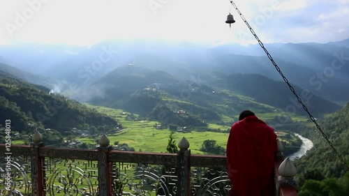 Bhutan monk on top of a monastery praying with a view over the Punakha area