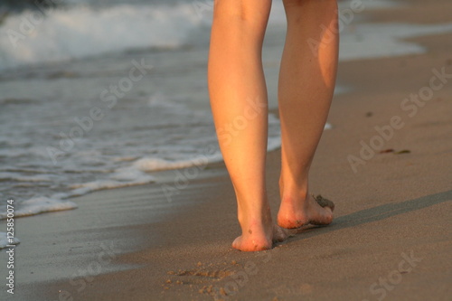 Frauenbeine am Strand