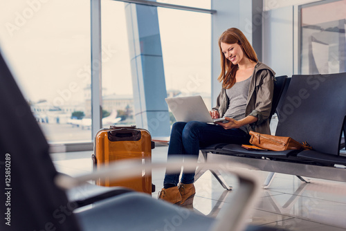 Beautiful girl using laptop in airport