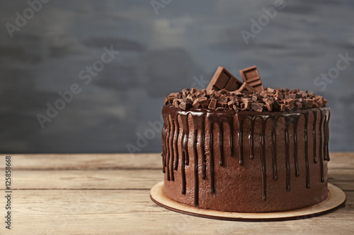 Tasty chocolate cake on grey wall background