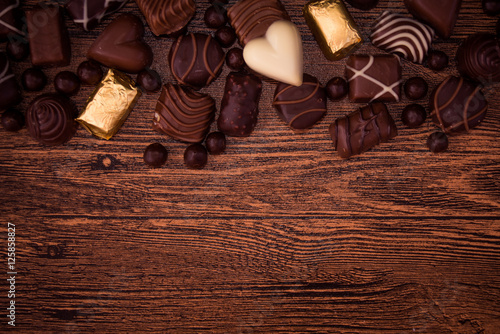 Assorted chocolates on wooden background