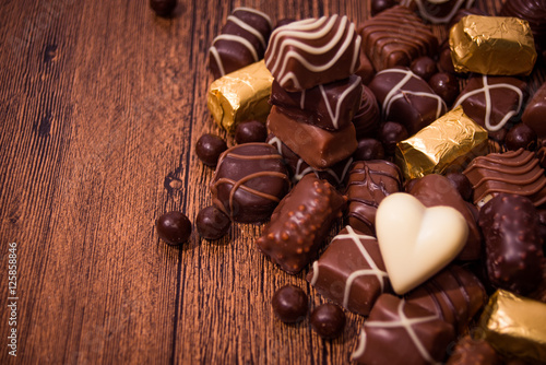 Assorted chocolates on wooden background