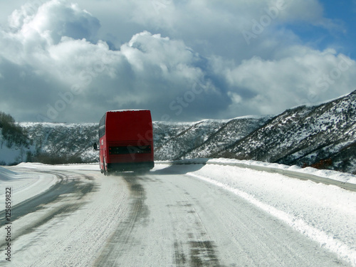 Red bus on icy winter highway near Wolcott, Colorado photo