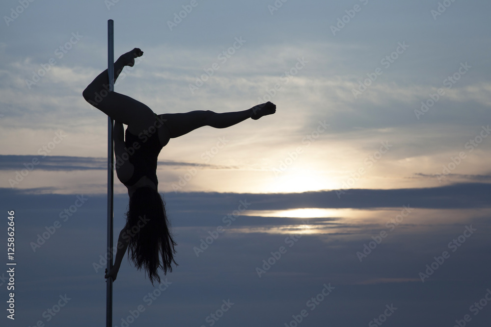 Element pole dance girl silhouette at sunset