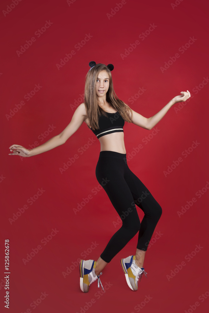 Funny girl standing on tiptoes. Isolated on red background Funny girl standing on tiptoes. Isolated on red background