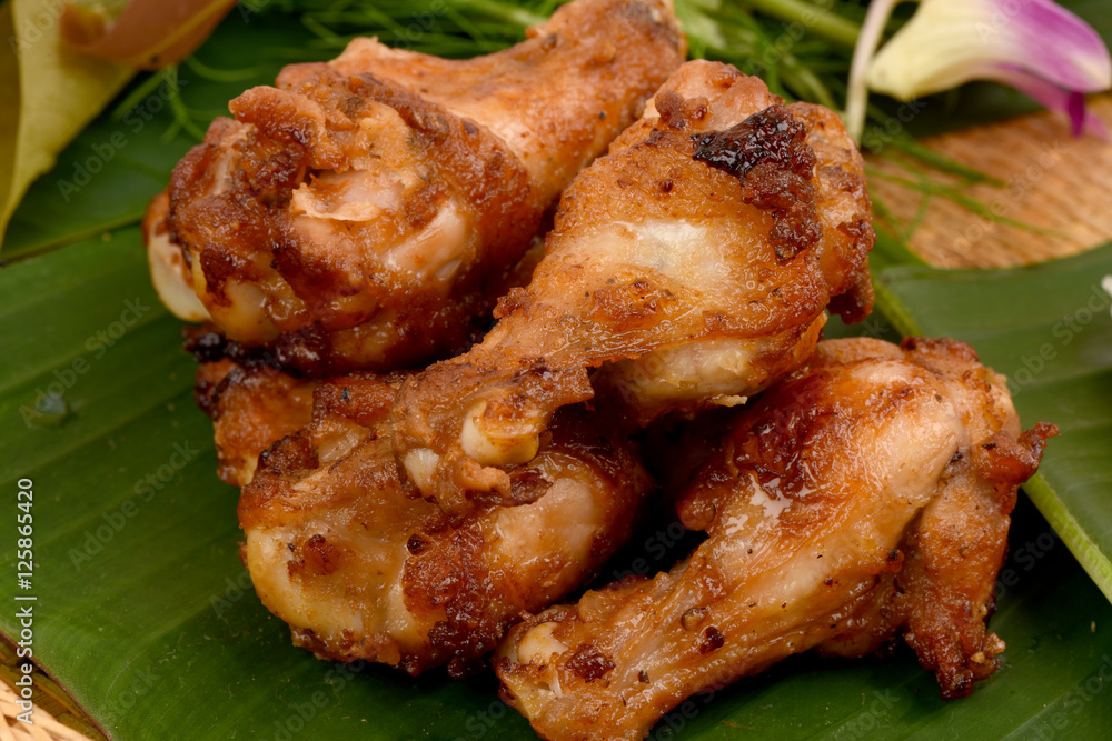Fried chicken on a background of green banana leaves. Fried chicken on a background of green banana leaves.