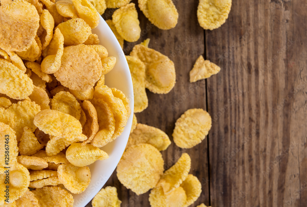 Background with cornflakes on old wooden table Background with cornflakes on old wooden table