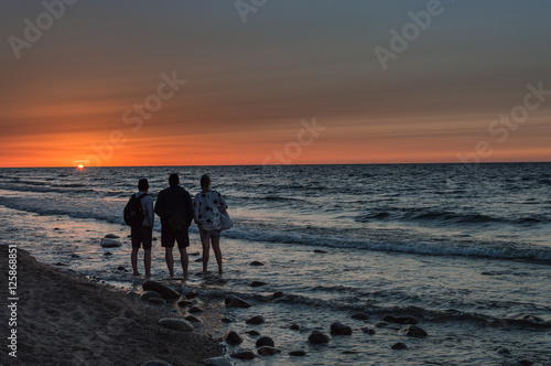 Group of people enjoying sunset at sea shore