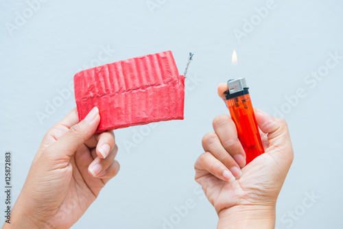 Red firecrackers and a lighter in hand
