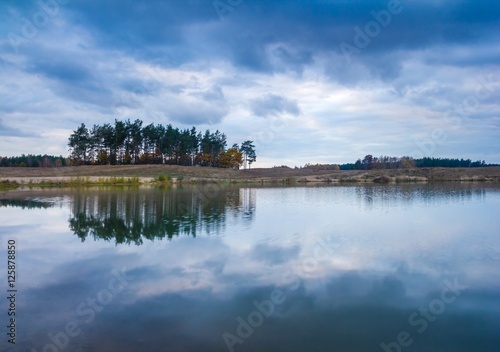 Small lake under dark cloudy sky