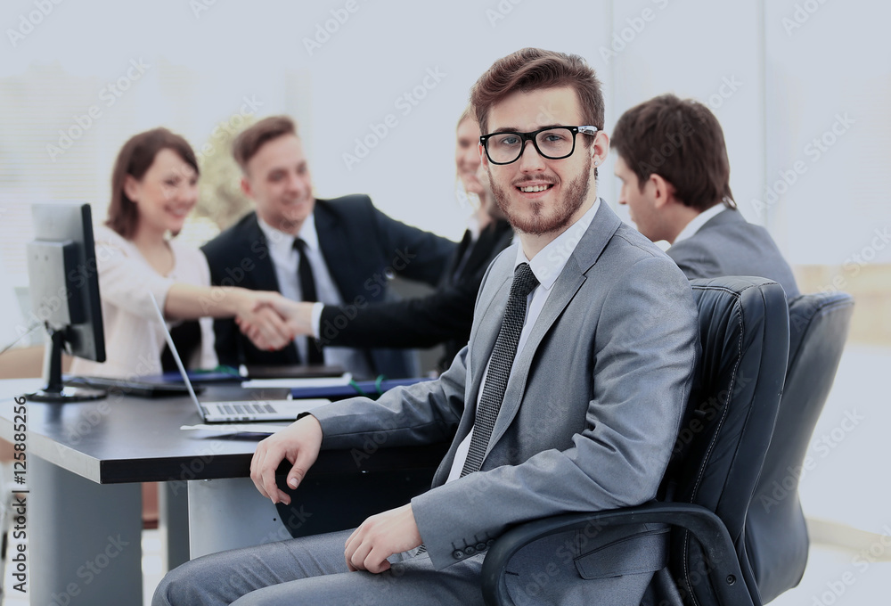 Portrait of mature business man smiling during meeting with colleagues in background Portrait of mature business man smiling during meeting with colleagues in background