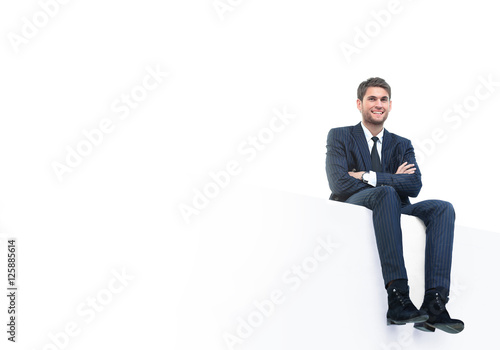 handsome young business man sitting on a white top © ASDF