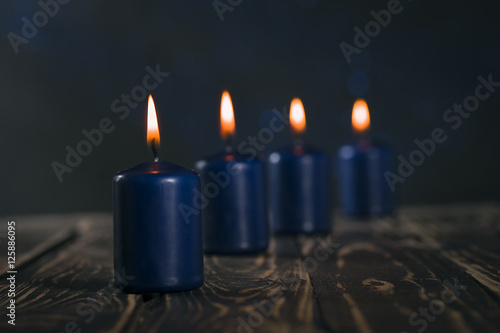 Lit four blue candles on wooden counter