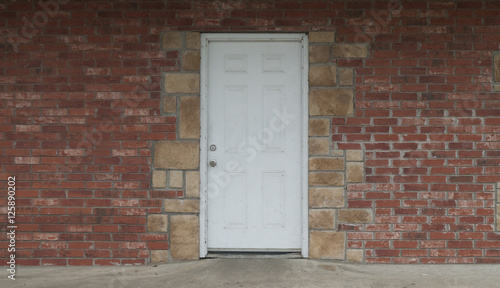 Rustic white door on brick and stone exterior all