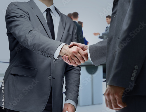 Business partners shaking hands in meeting hall