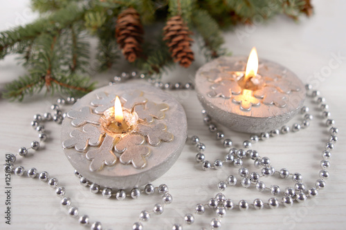 Silver  candles  with snowflakes. Winter, Christmas decoration on wooden  background
